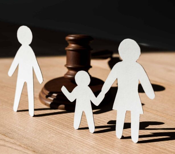 paper people near wooden gavel on table, divorce concept